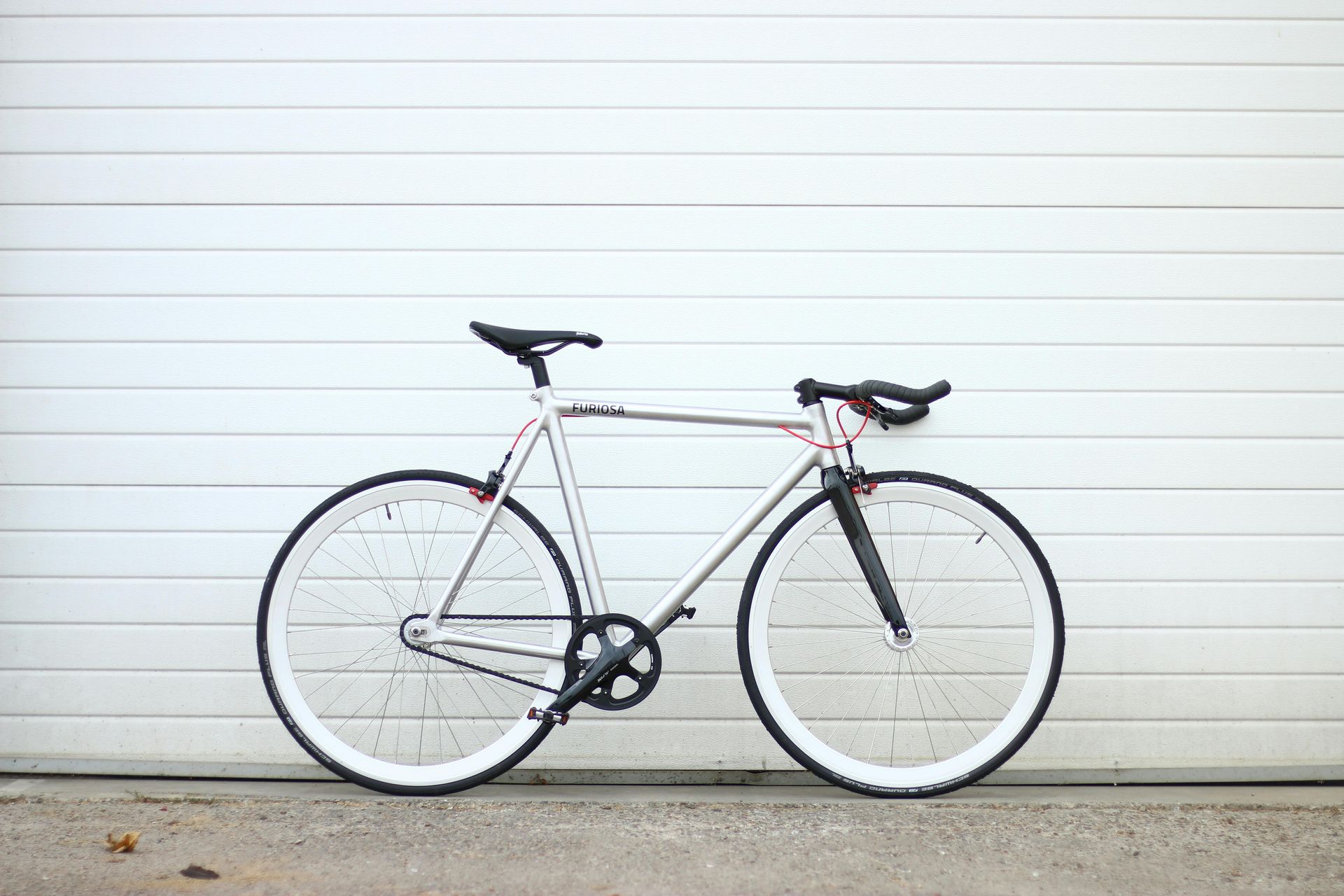 Vor einem weißen Garagentor steht ein Fahrrad.