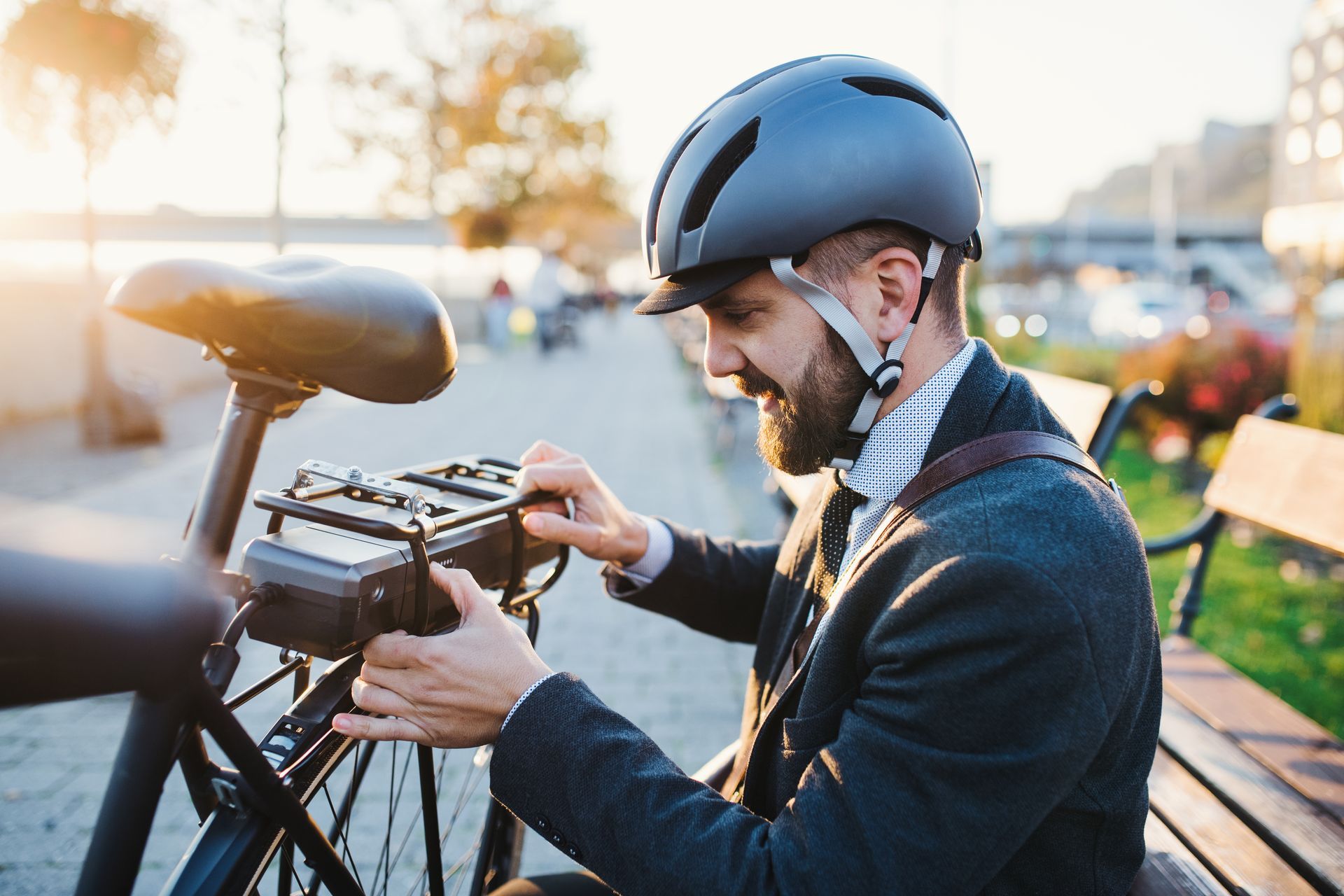 Personne vérifiant la batterie d’un vélo électrique en extérieur