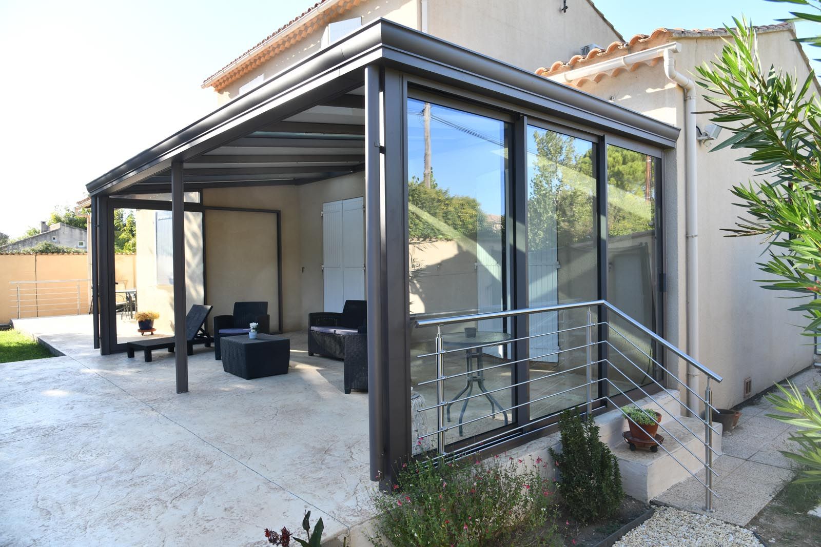 Maison avec une véranda et un salon de jardin à l'intérieur
