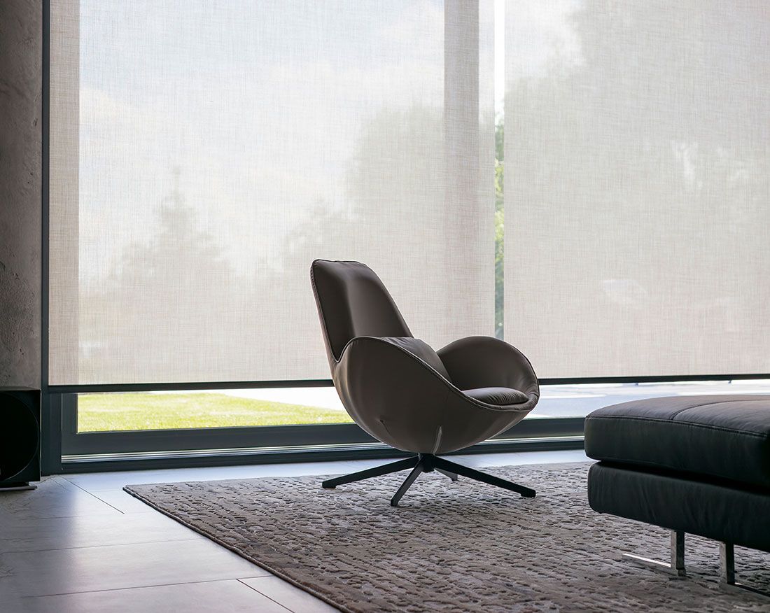 Focus sur des stores dans une chambre avec un fauteuil