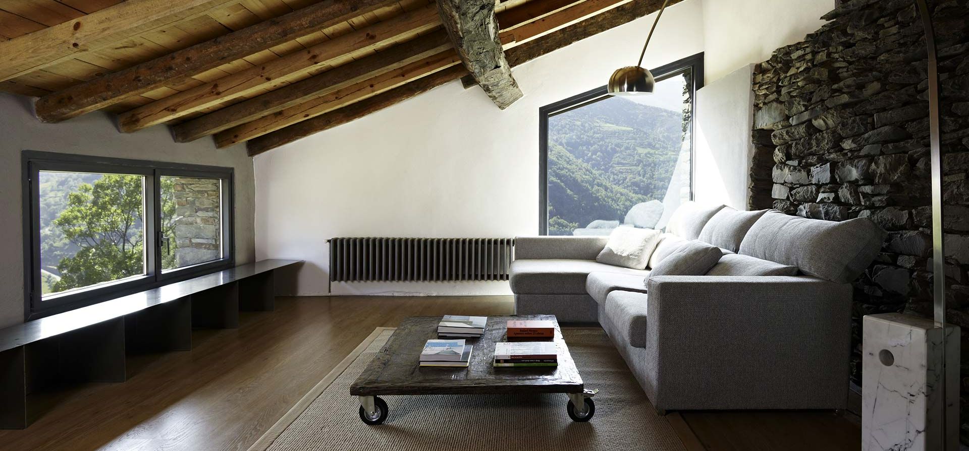 Intérieur d'un salon design avec mur en pierre et fenêtre en aluminium