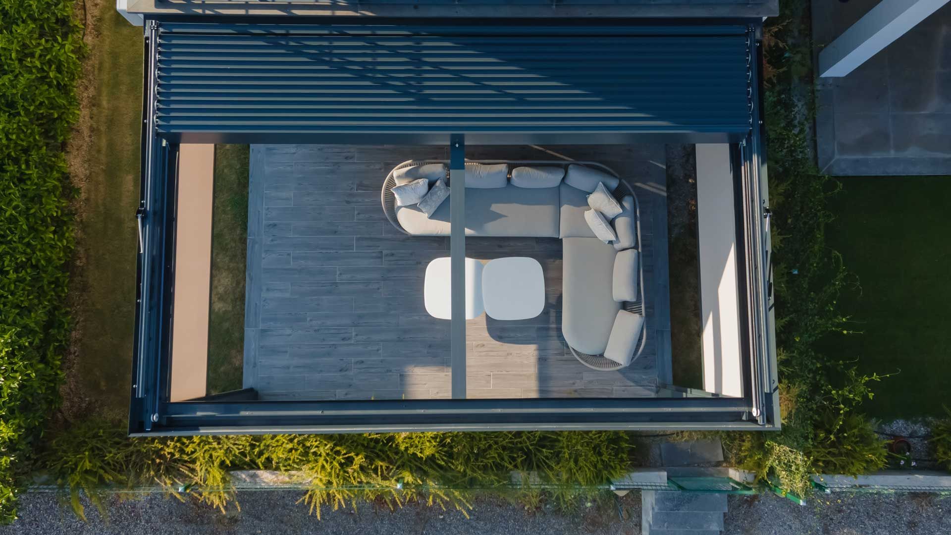 Vue aérienne d'un store extérieur sur un terrasse et un salon de jardin