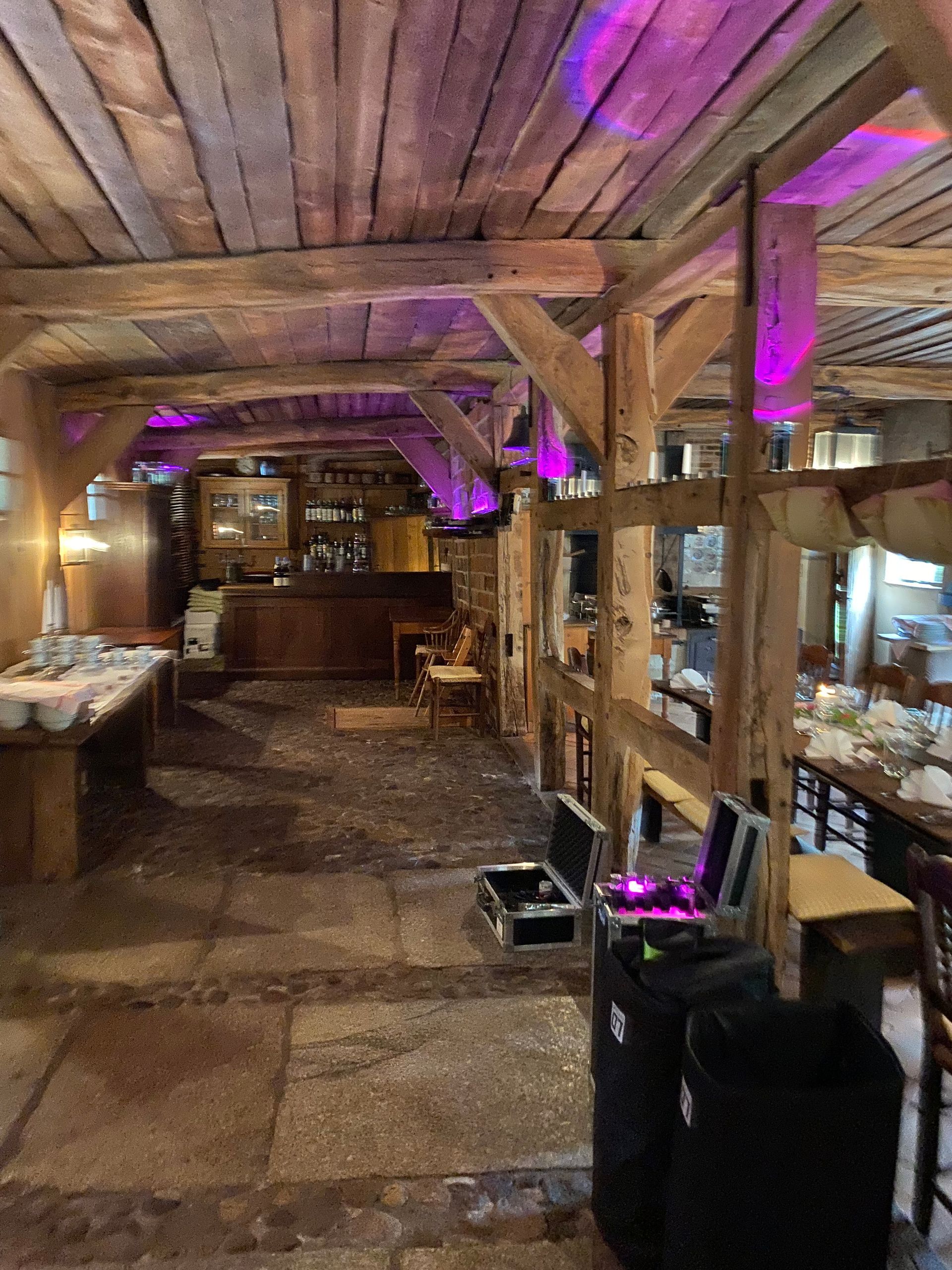 Ein großer Raum mit Holzbalken und Tischen und Stühlen.