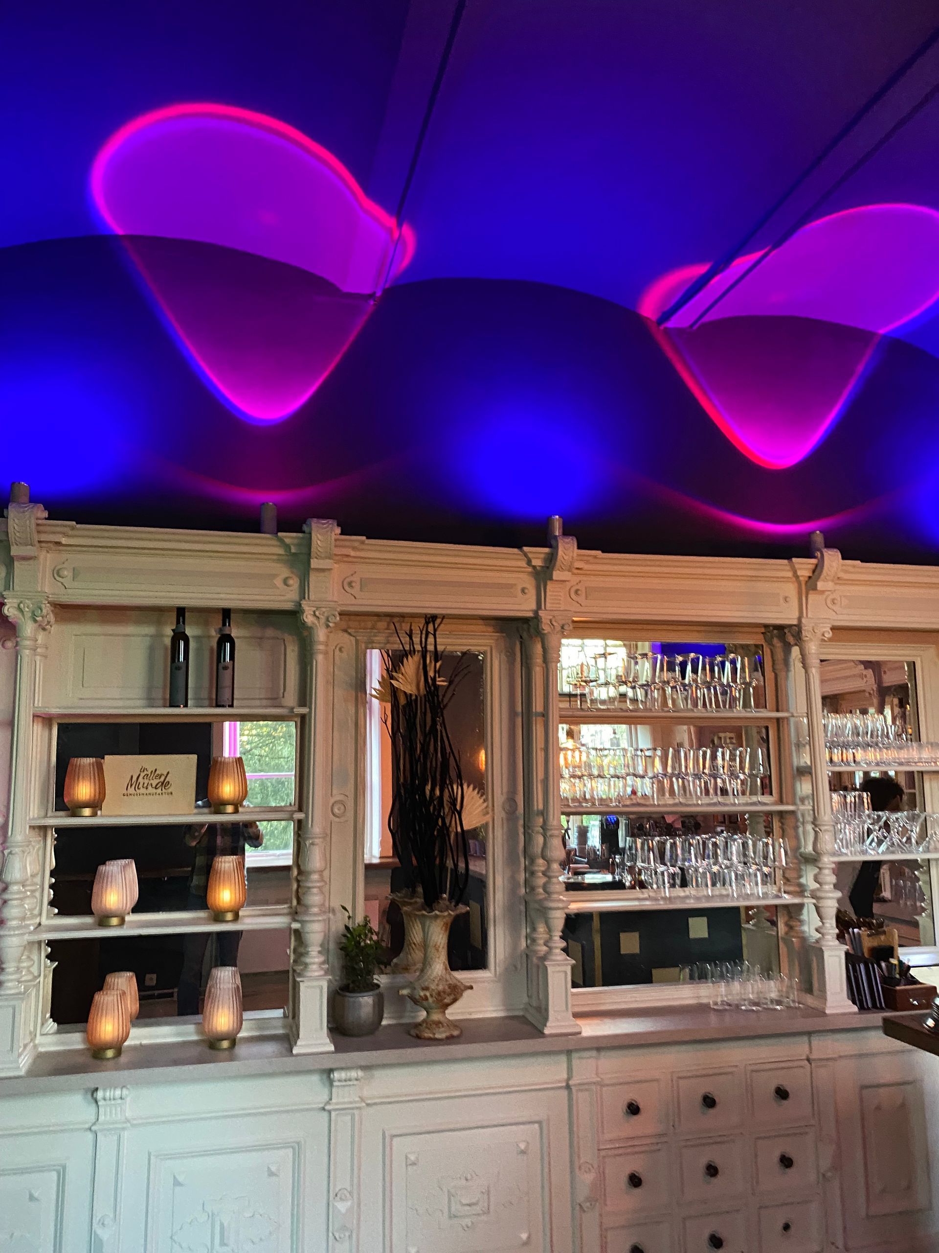 Ein Raum mit einer violetten Decke und einem Regal mit Kerzen darauf