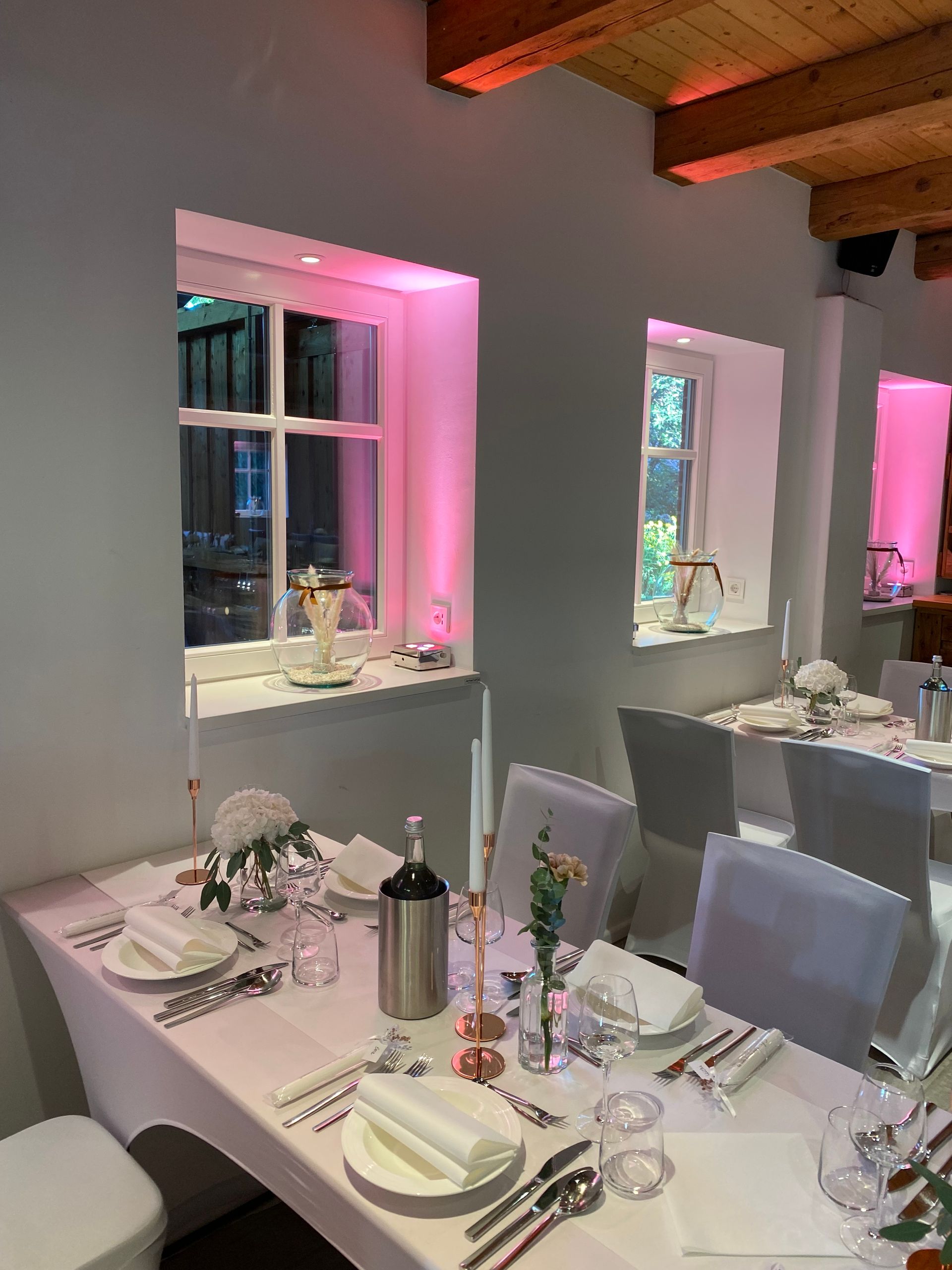 Ein Esszimmer mit Tischen und Stühlen für einen Hochzeitsempfang.