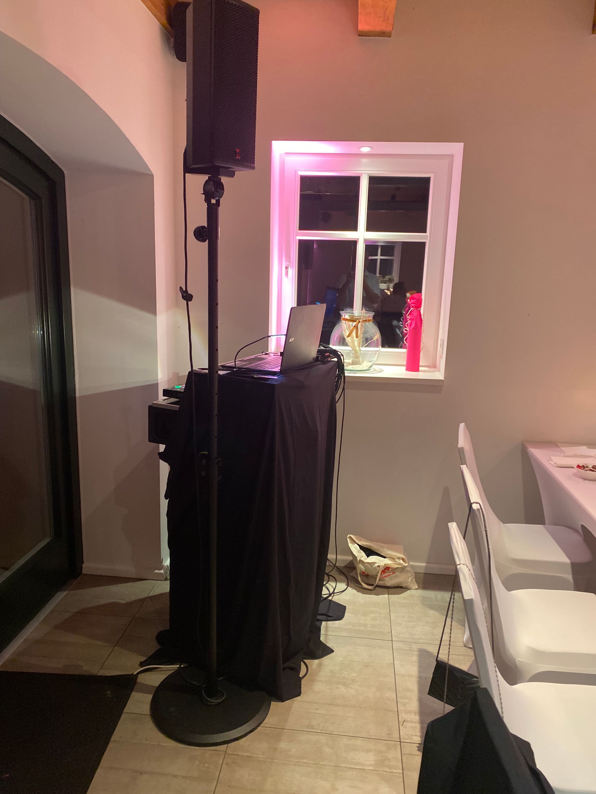 Ein Raum mit Tischen und Stühlen und einer DJ-Kabine