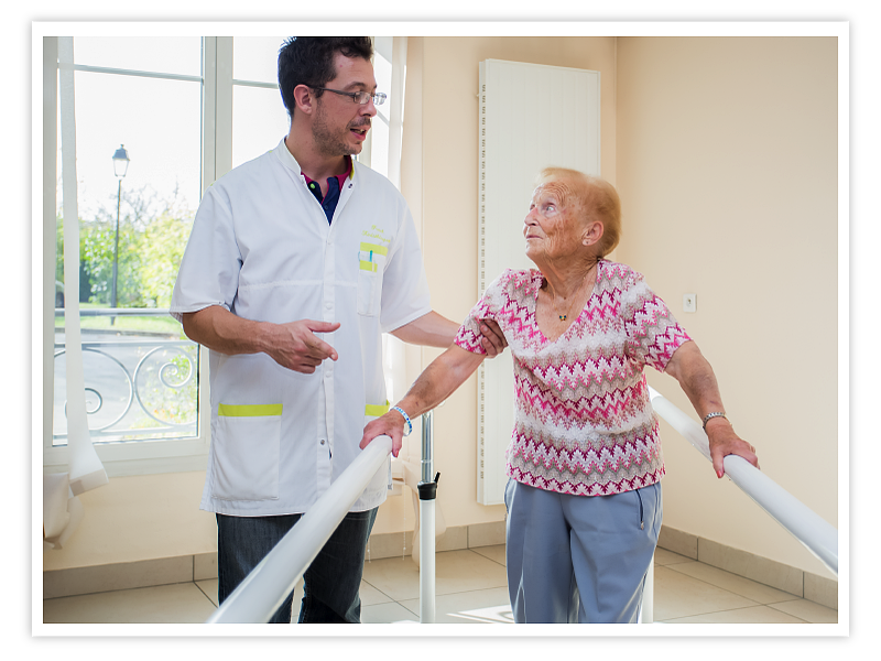 Soins Kiné qui aide une patiente à marcher