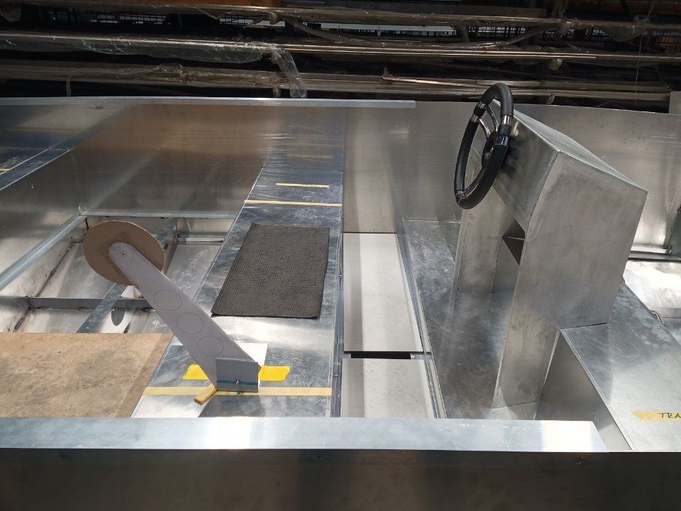 Industrielle Metallkonstruktion mit Handrad, Rampen und grauen Paneelen in einer Fabrikumgebung