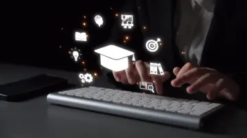 Persona escribiendo en un teclado con iconos educativos flotantes, incluyendo un birrete de graduación.