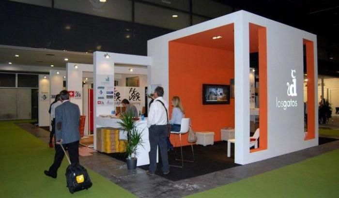 Un grupo de personas se encuentran alrededor de un stand en una convención.