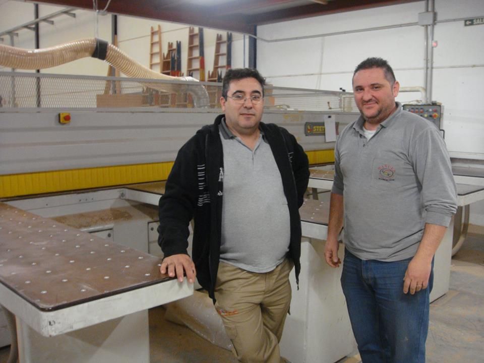 Dos hombres parados frente a una máquina que dice delta