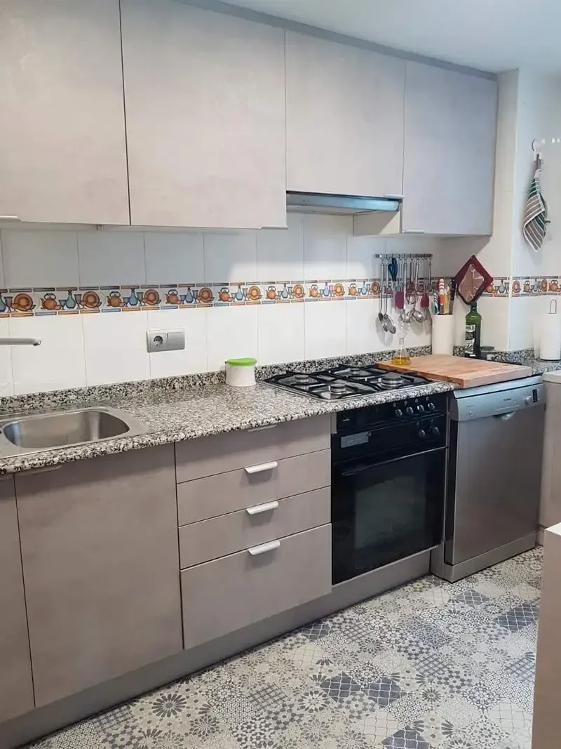 Una cocina con electrodomésticos de acero inoxidable y encimeras de granito.