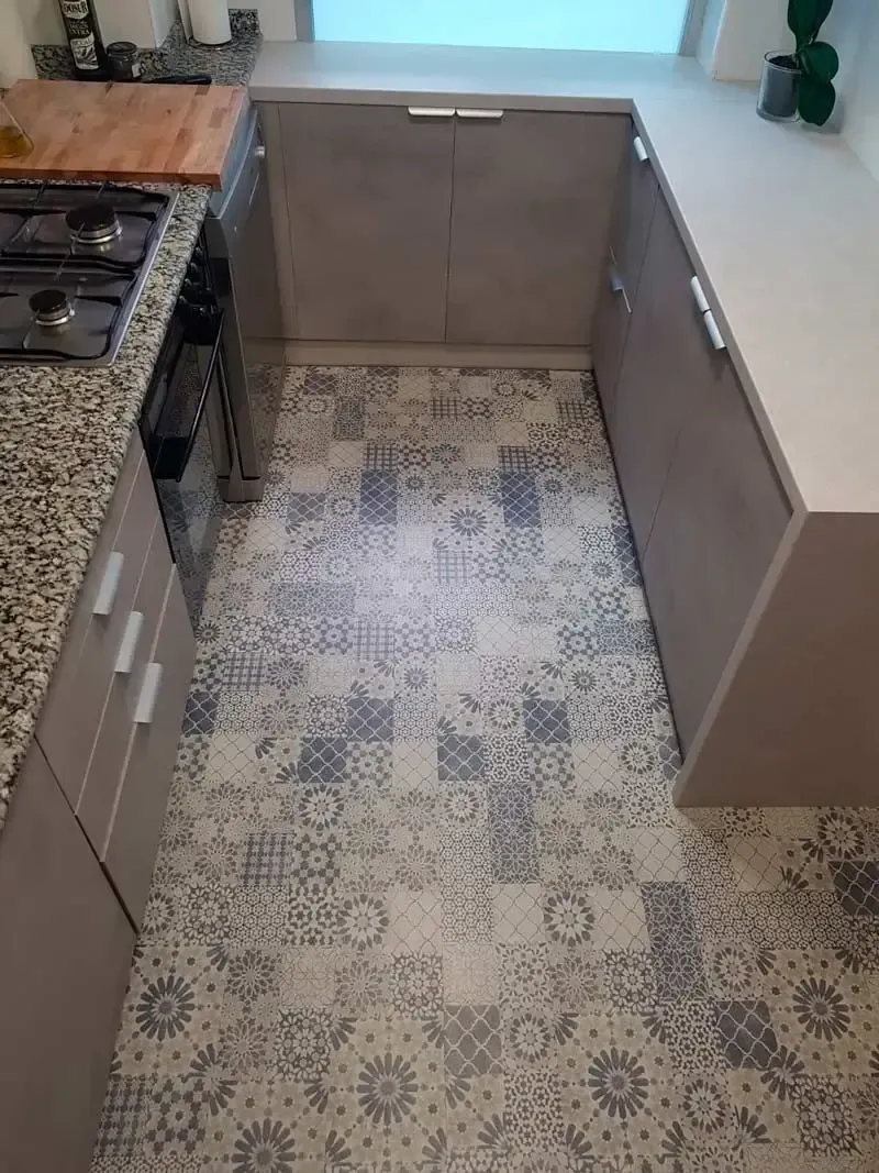 Una cocina con suelo de baldosas y horno eléctrico.