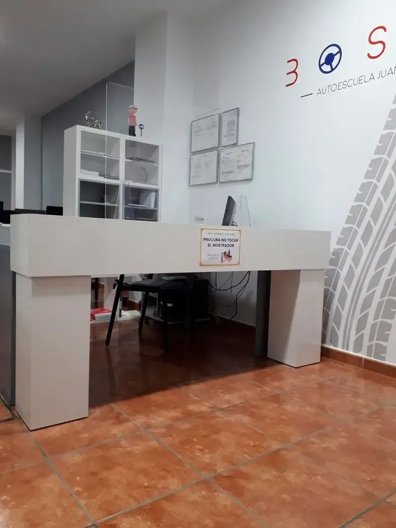 Un escritorio blanco en una habitación con una huella de neumático en la pared.