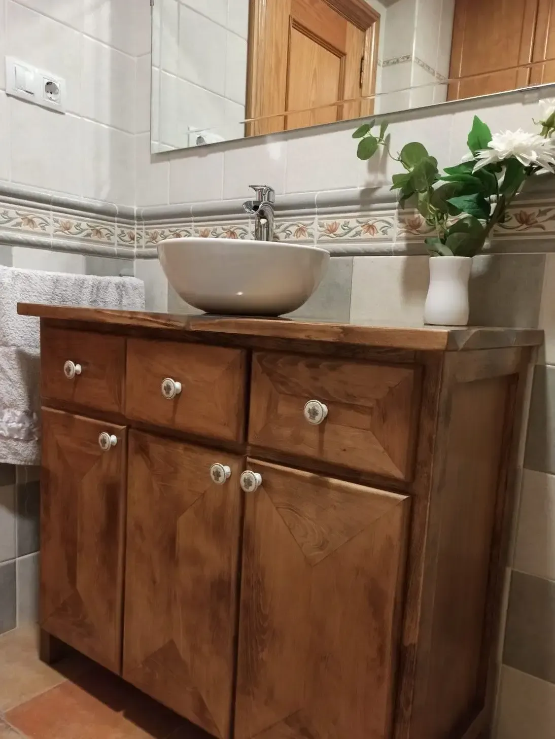 Un baño con tocador de madera y lavabo.
