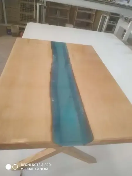 Una mesa de madera con un río azul en el medio.