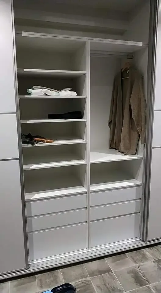 Hay un abrigo colgado en una percha en el armario.