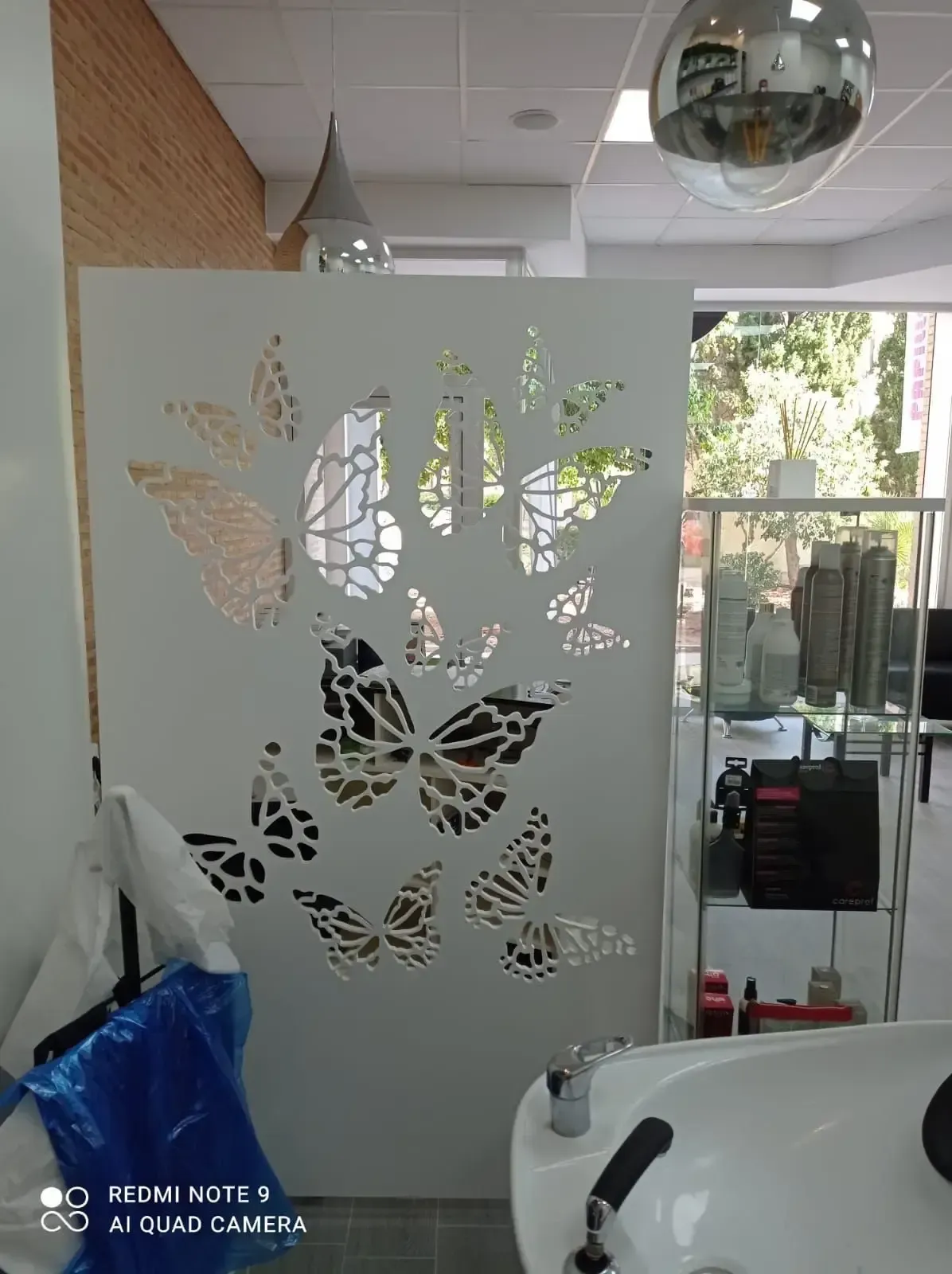 Una pared blanca con mariposas recortadas en un salón.