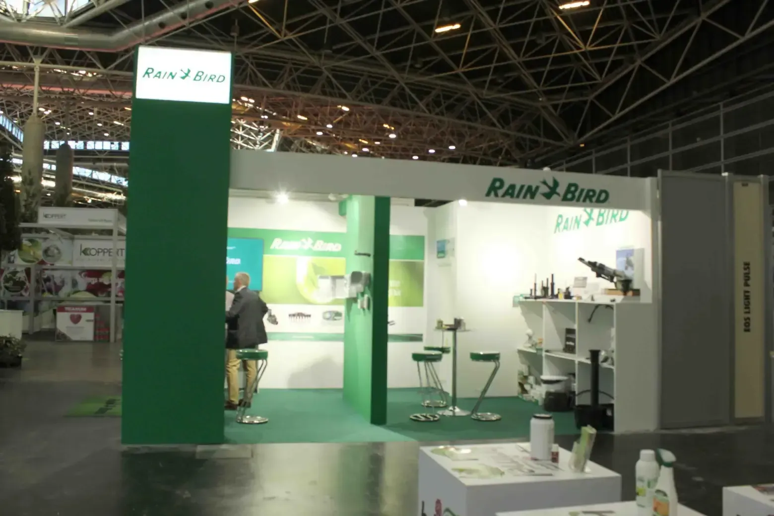 Un stand de Rain Bird verde y blanco en una convención