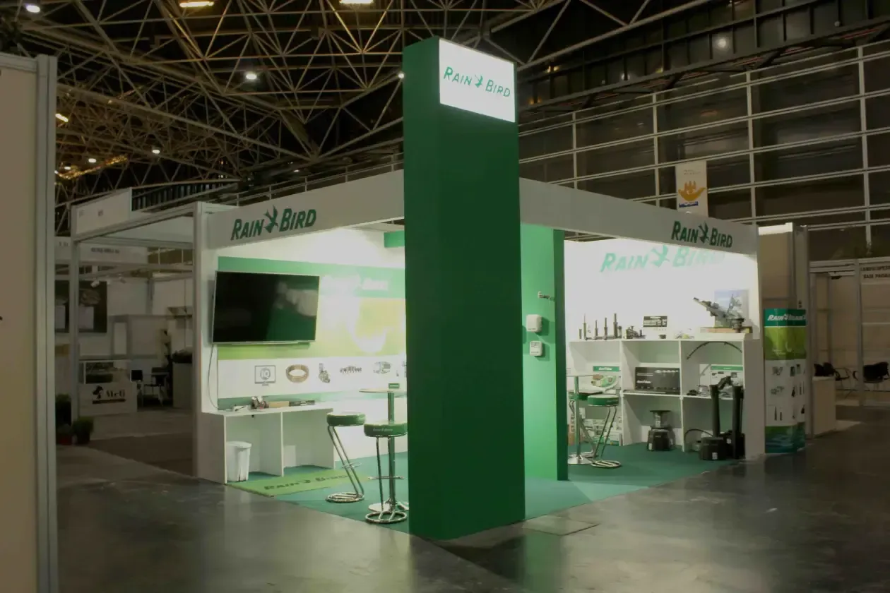 Una cabina verde y blanca con un televisor en la pared.