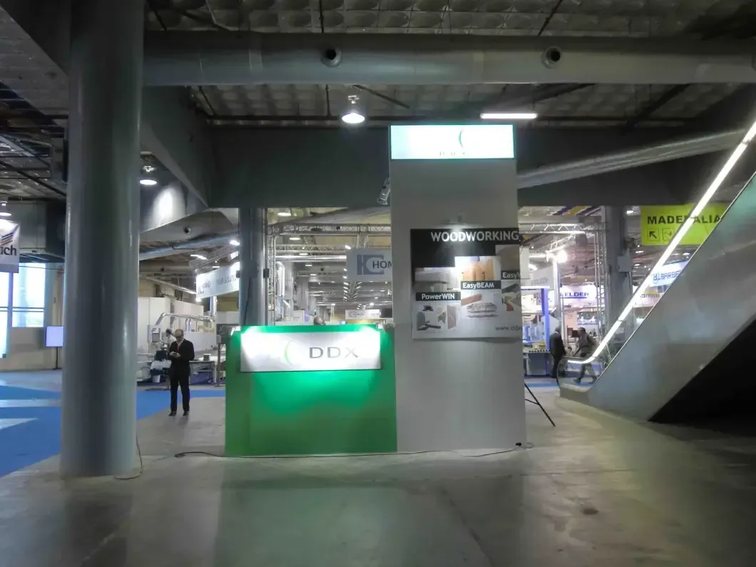 Un hombre está parado frente a una cabina verde y blanca en un edificio.