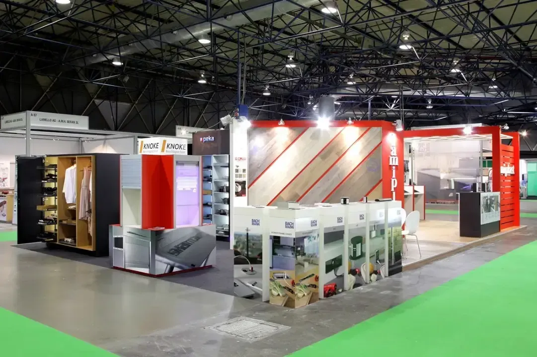 Una sala grande con muchos expositores y una alfombra verde.