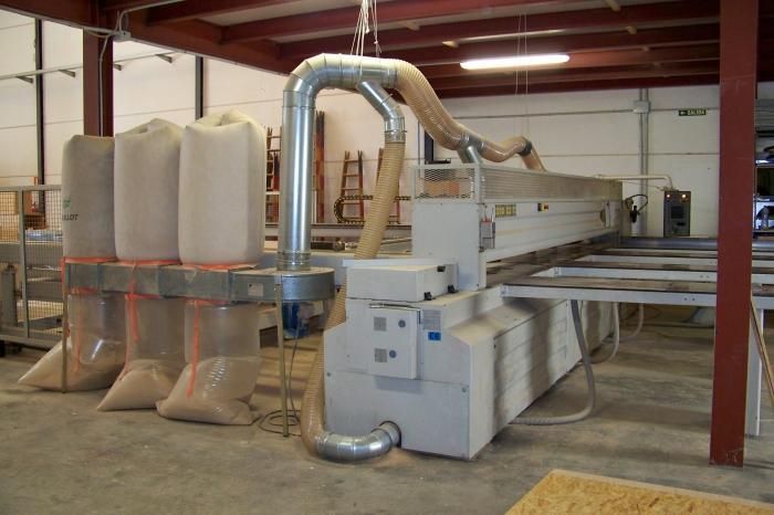 Una máquina en una fábrica con bolsas de madera delante de ella.