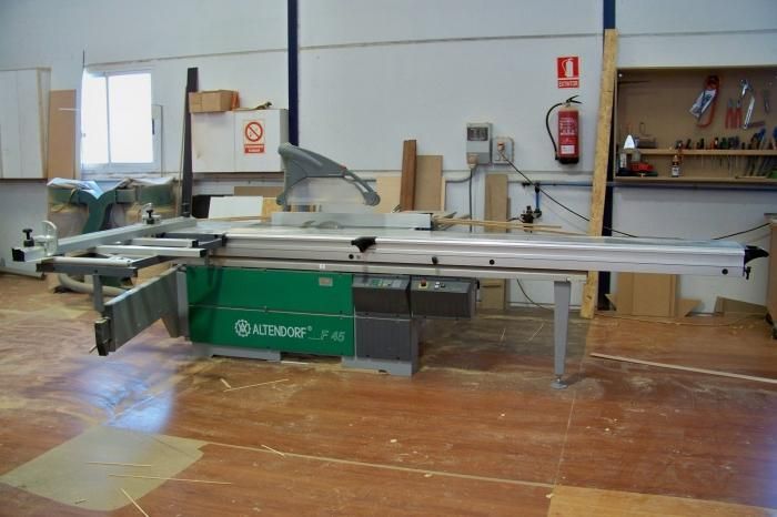 Una sierra circular está en un taller junto a un extintor de incendios.