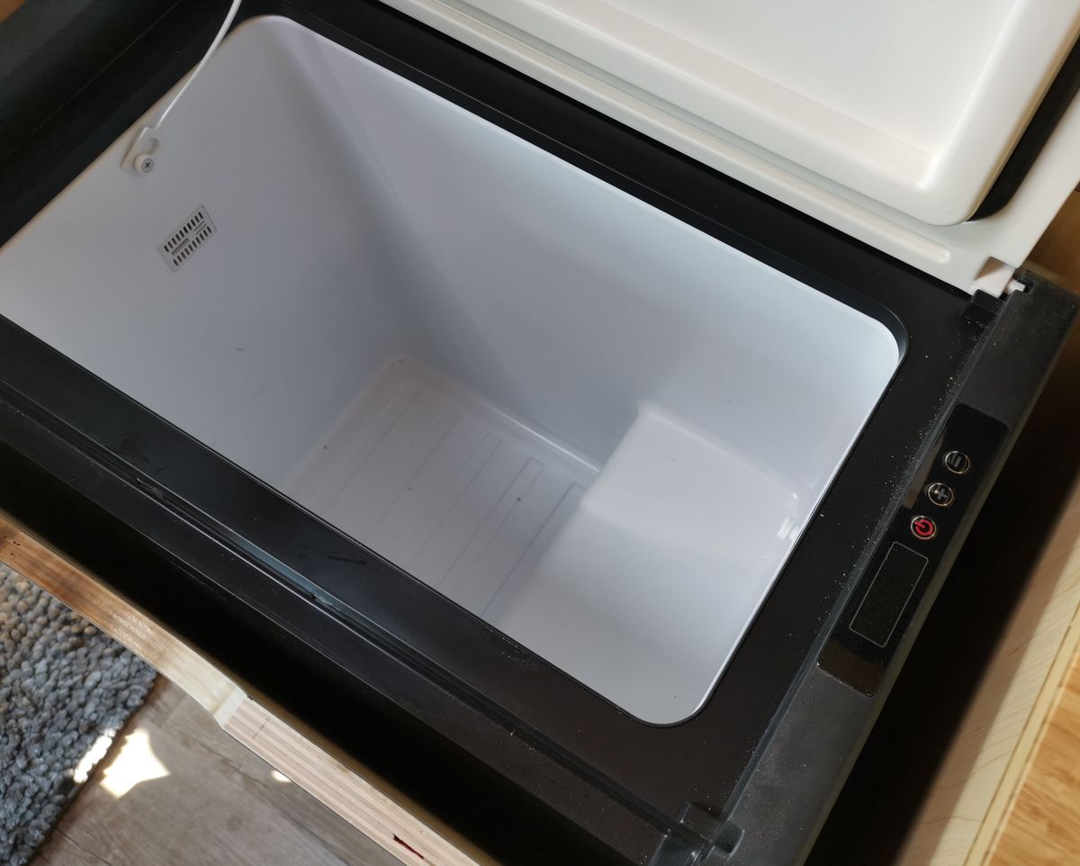 ein schwarzer Kühlschrank mit einem weißen Inneren