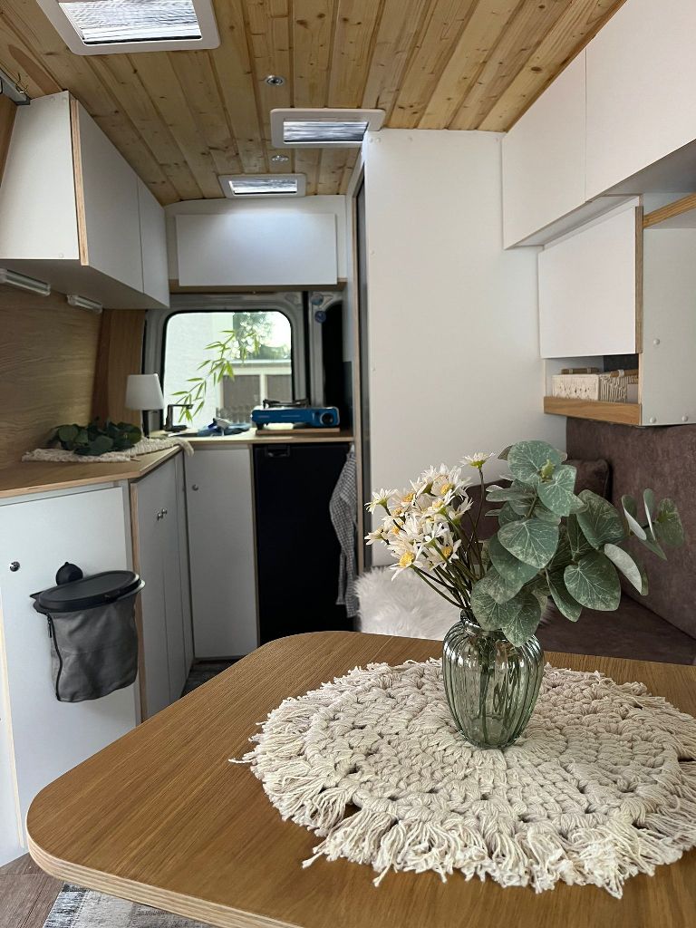 ein Tisch mit einer Vase mit Blumen darauf