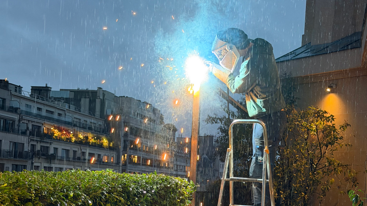 Un soudeur travaillant sur une échelle.