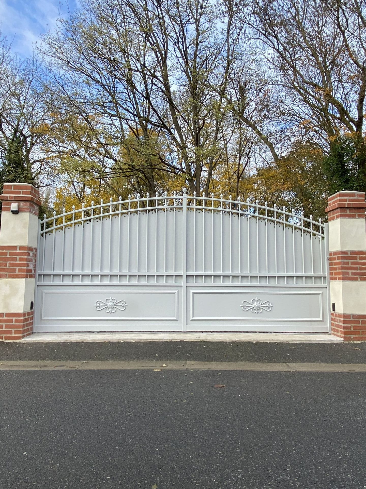 Portail blanc qui ne laisse pas voir l'intérieur de la propriété