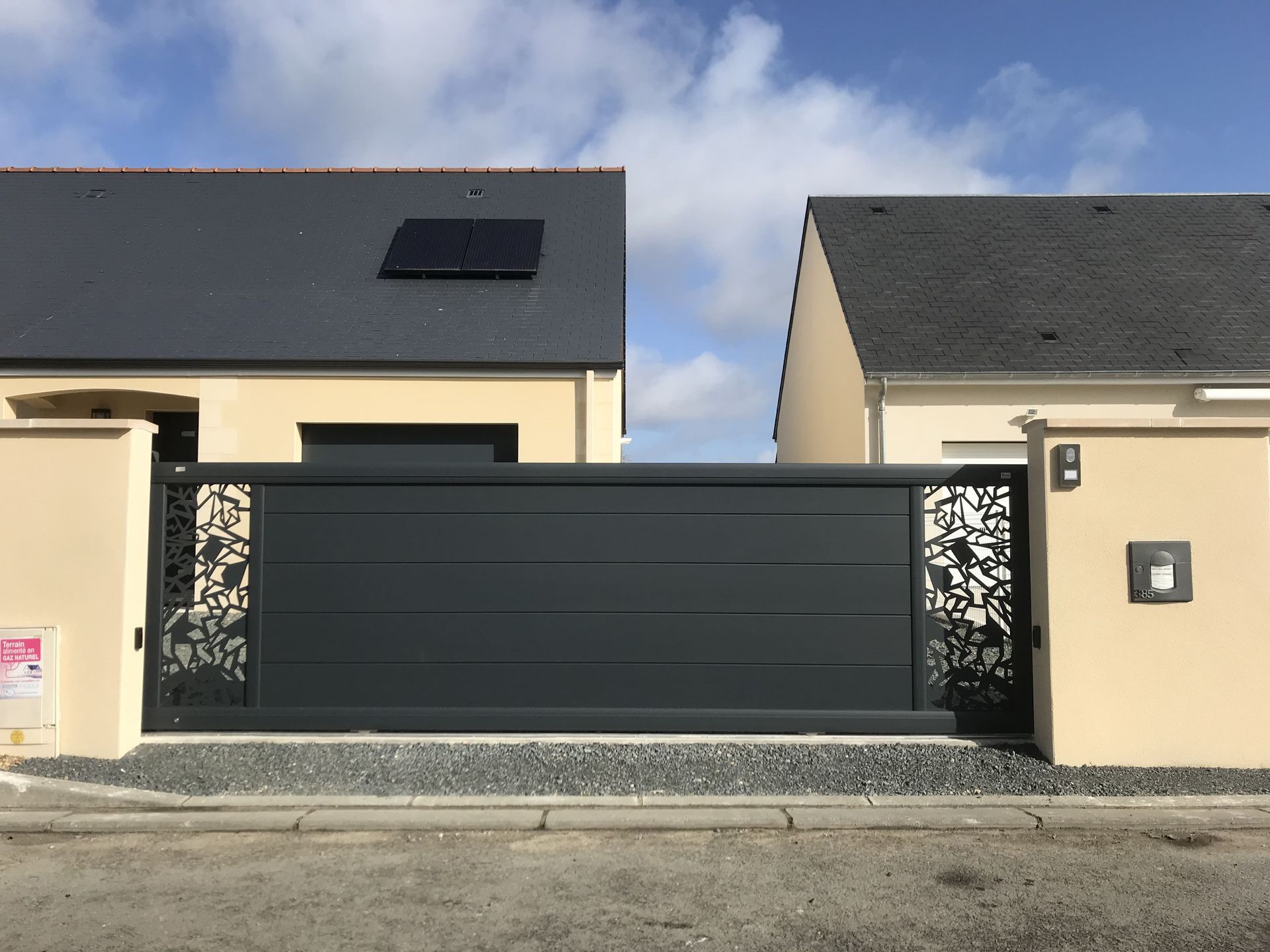 Portail coulissant en aluminium avec des rectangles de motifs incrustés à chaque bout