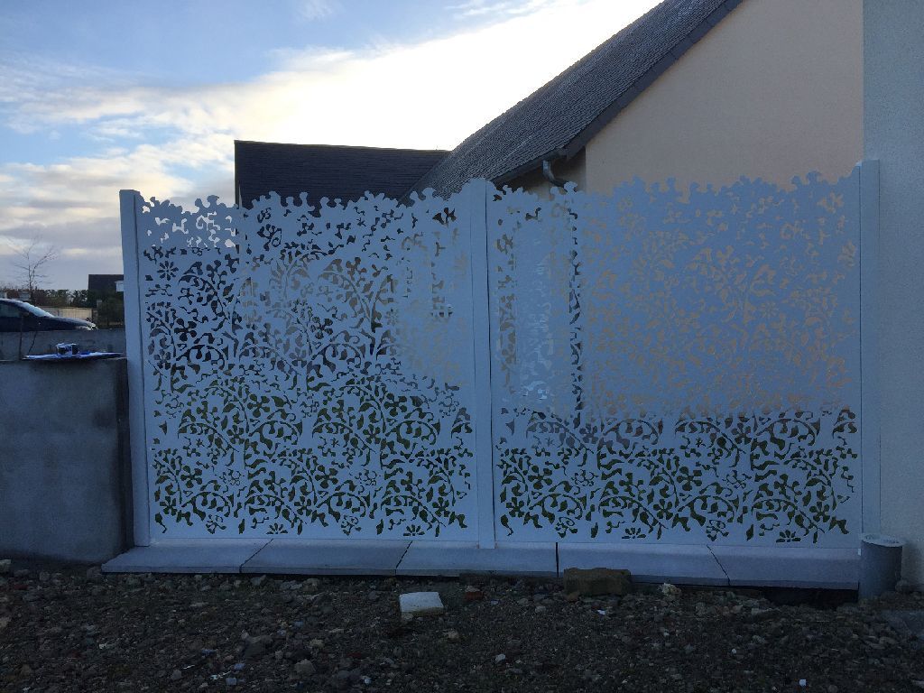 Portail blanc en aluminium avec des motifs gravés dedans