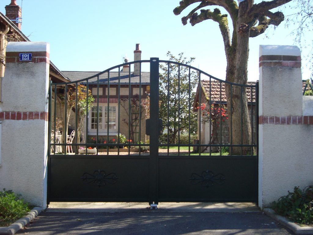 Portail d'une maison avec un arbre élagué derrière