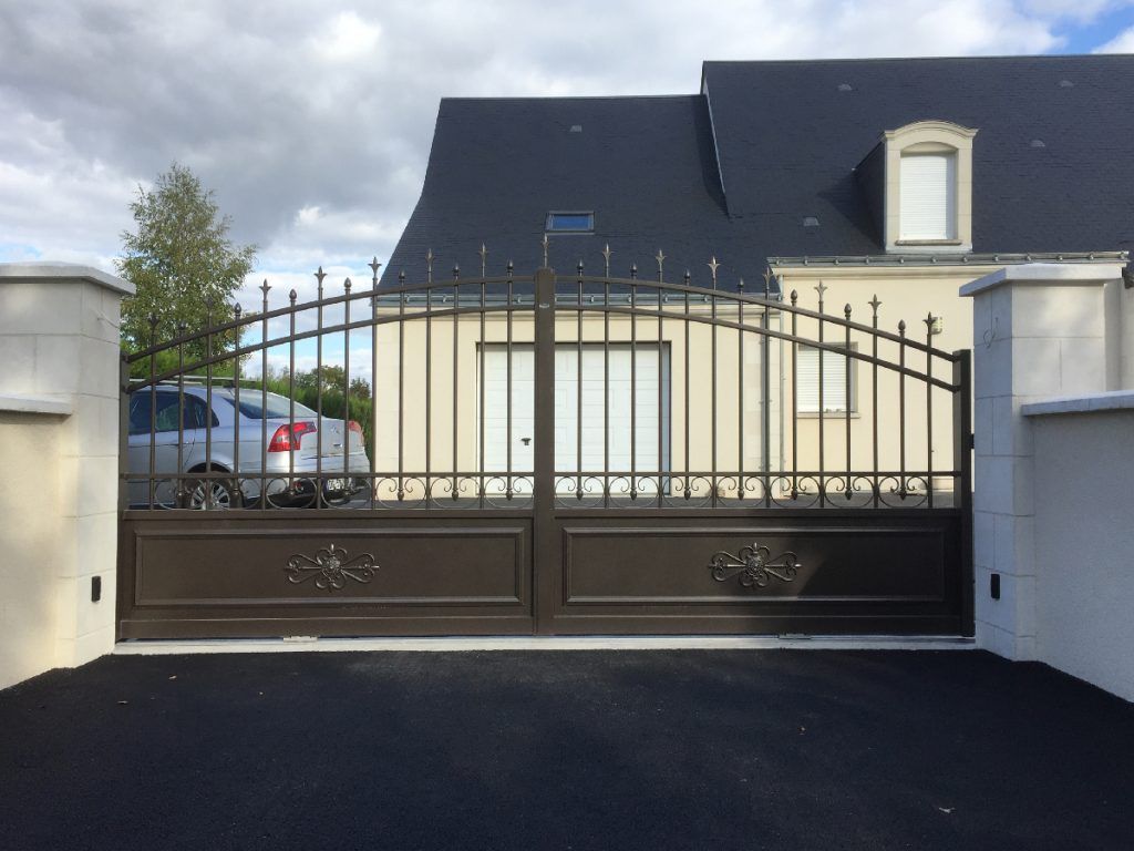 Portail noir d'une maison au toit en ardoise