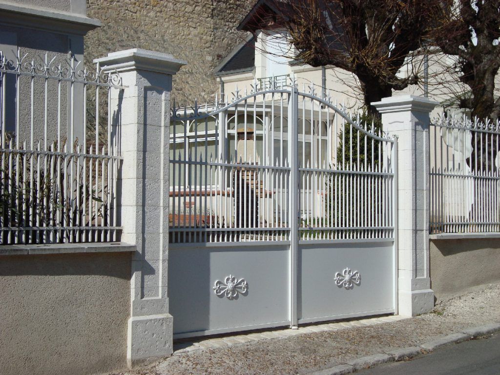 Portail blanc en fer et clôture en fer également