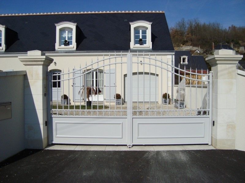 Portail blanc d'une maison avec des fenêtres sur le toit
