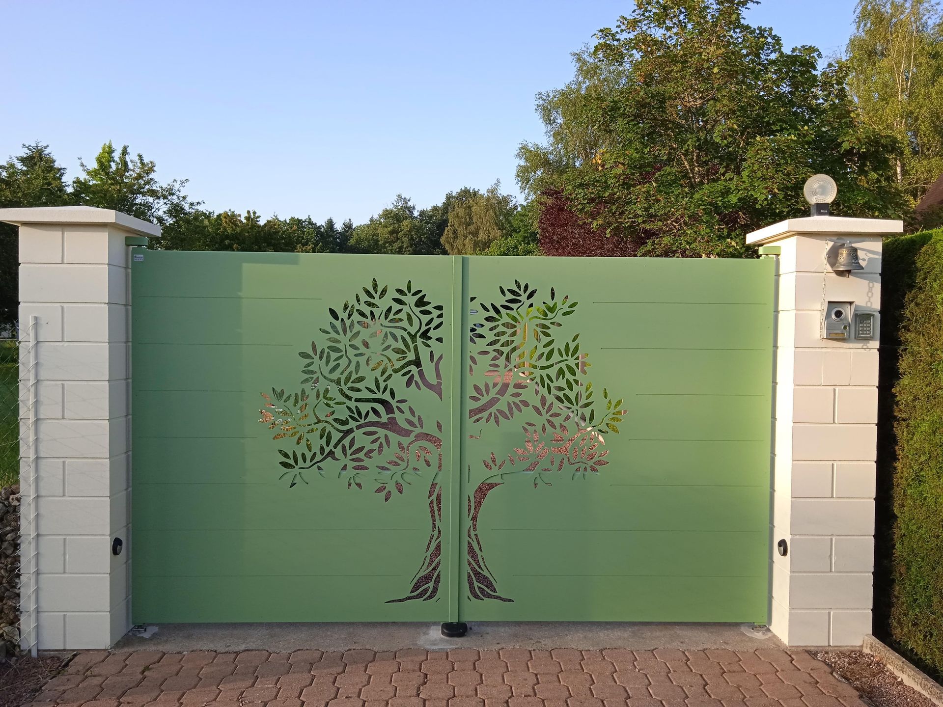 Portail en alu vert avec un arbre gravé dedans