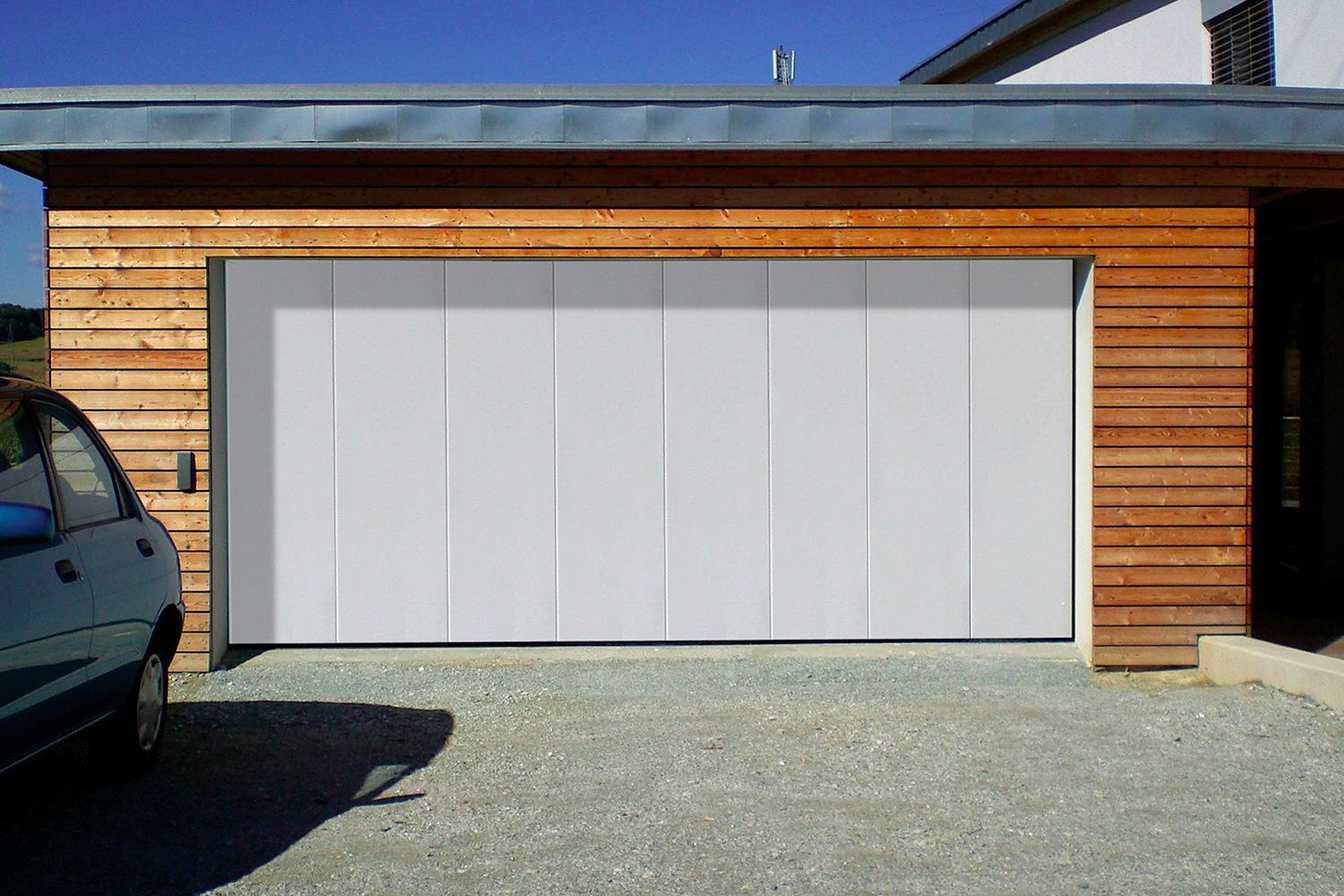 porte de garage blanche avec une maison en bois