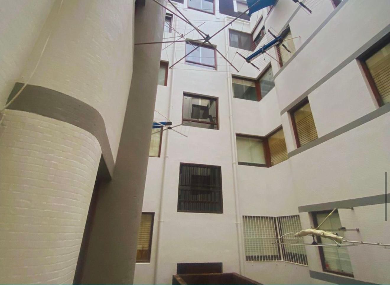 Una casa con una mesa y plantas en macetas delante de ella.