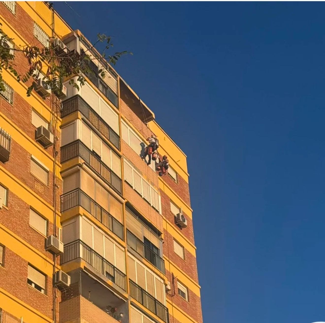 Un edificio blanco con un aire acondicionado Baxi en el lateral.