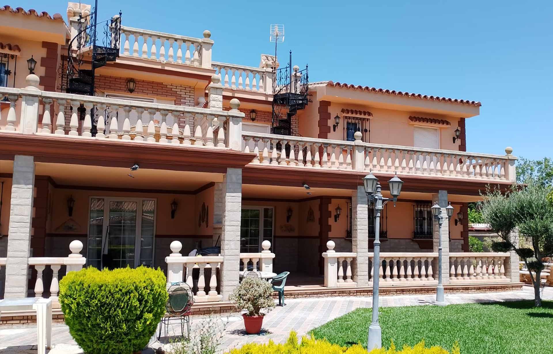 Una casa con una mesa y plantas en macetas delante de ella.