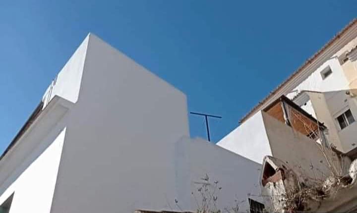 Un edificio blanco con un cielo azul al fondo.