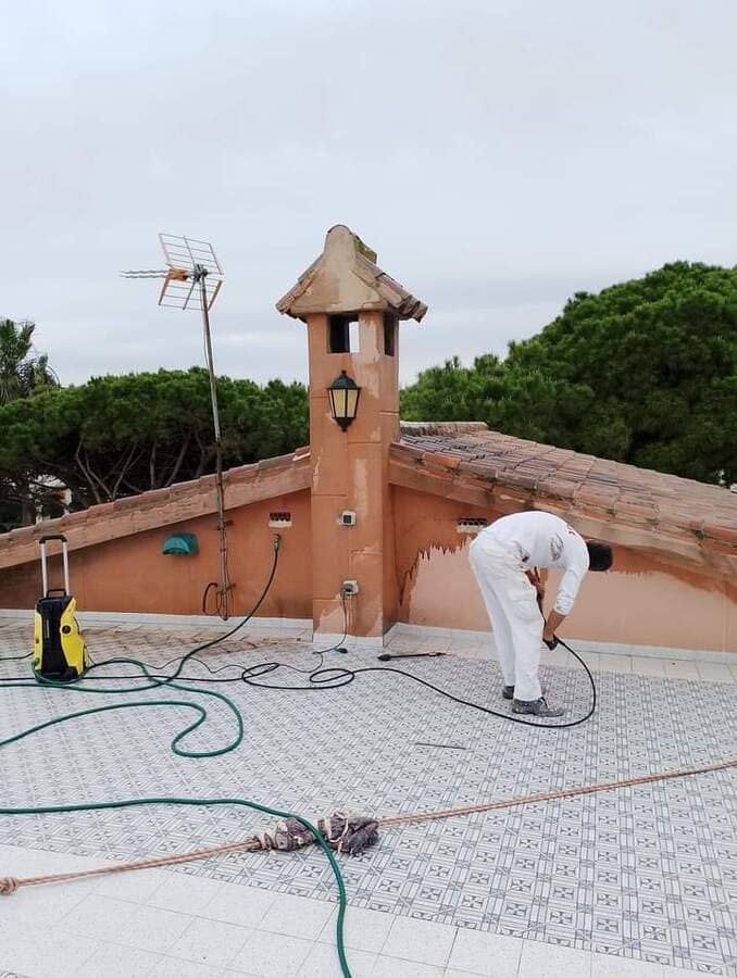 Un hombre está trabajando en el tejado de un edificio.