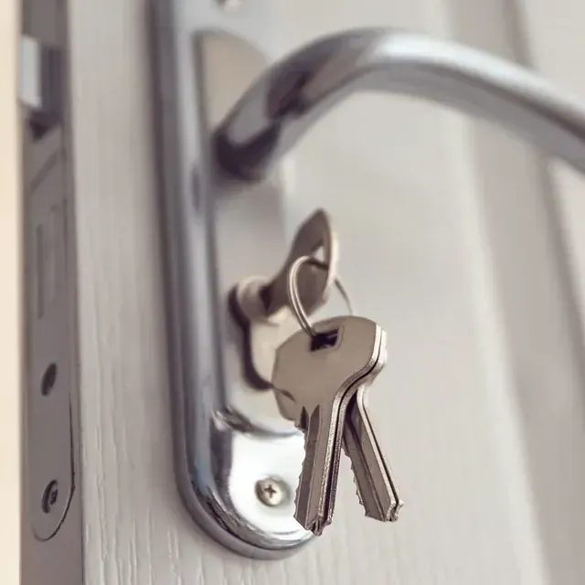 Un primer plano de una cerradura de puerta con dos llaves dentro.