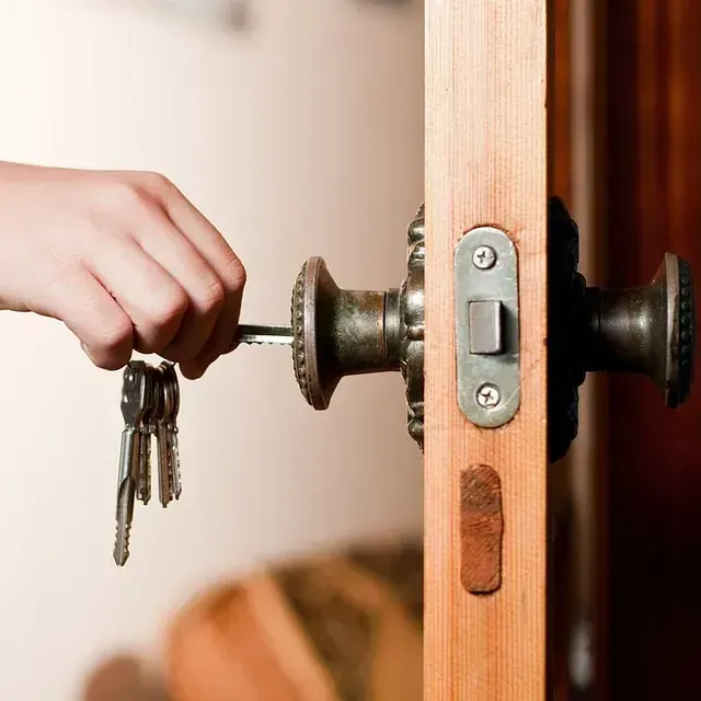 Una persona está abriendo una puerta con llaves en la mano.