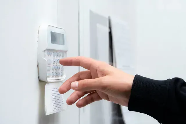 Una persona está presionando un botón en un sistema de seguridad.