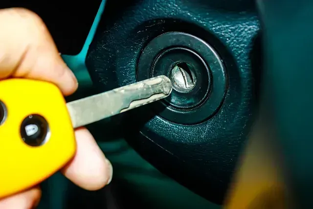 Una persona sostiene en su mano una llave de coche amarilla.