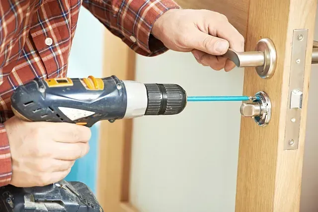 Una persona está arreglando una cerradura de puerta con un destornillador.